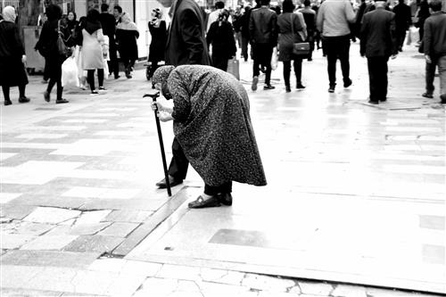 زهرا اصغری : فقر ، پیرزنی با کمری خموده در حال تکدی گری در بازار تهران