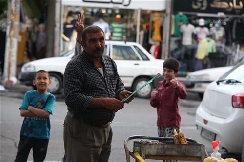 سارا میرحسینی : بلال  ، مردی در حال درست کردن بلال در یکی از روزهای تیر ماه سال 96 که در خیابان رجایی شهر  تهران مستقر شده و سه  کودک که در حال شوخی و ادا در آوردن برای دست فروش هستند
